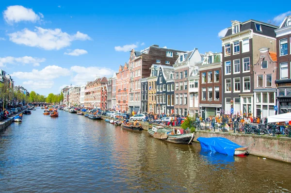 AMSTERDAM-ABRIL 27: Amsterdam Canal Singel con barcos a lo largo de la orilla del canal en el Día del Rey, el 27 de abril de 2015 . — Foto de Stock