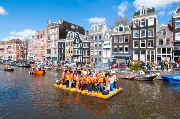 AMSTERDAM-APRIL 27: Happy People celebrate King's Day along the Singel canal on the orange raft on April 27,2015. — Stockfoto