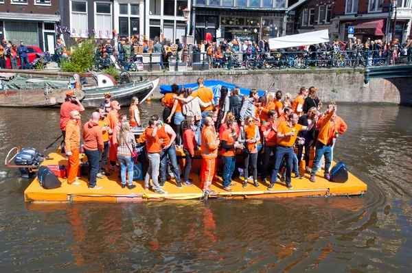 AMSTERDAM-APRIL 27: People in orange celebrate King's Day along the Singel canal on the raft on April 27,2015. — Stock Photo, Image