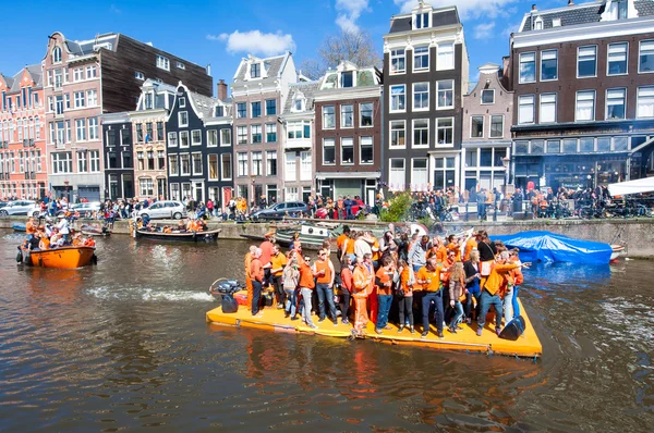 AMSTERDAM-APRIL 27: Happy People in orange celebrate King's Day along the Singel canal on the raft on April 27,2015. — Stockfoto