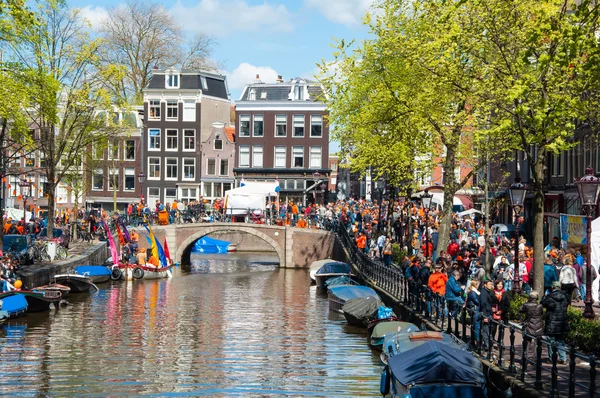 АМСТЕРДАМ-АПРЕЛЬ 27: Толпа людей идет вдоль улицы Амстердама, чтобы отметить День короля 27 апреля 2015 года . — стоковое фото