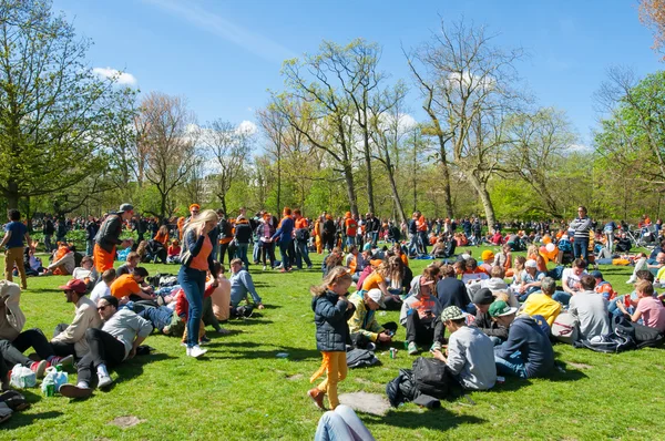 AMSTERDAM-APRIL 27: Locals and tourists in orange celebrate King's Day in on April 27,2015 in Vondelpark, the Netherlands. — Stok fotoğraf