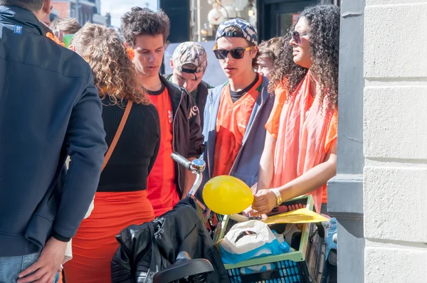 AMSTERDAM-APRIL 27: Unidentified woman sells laughing gas to young men during King's Day on April 27,2015 in Amsterdam, the Netherlands. — Stockfoto