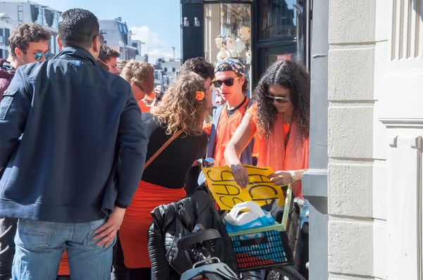 АМСТЕРДАМ-АПРЕЛЬ 27: Неизвестная продает смеющийся газ молодым людям во время Дня короля 27 апреля 2015 года в Амстердаме, Нидерланды . — стоковое фото