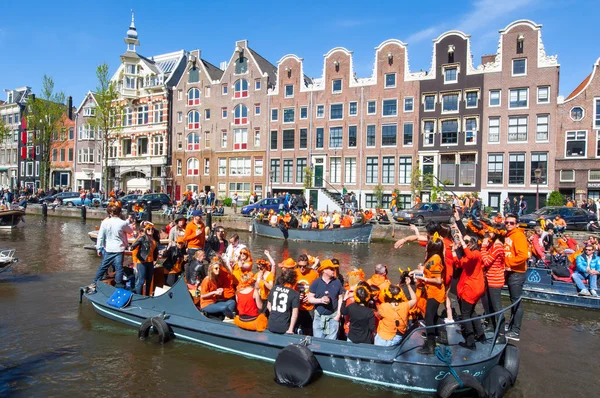 AMSTERDAM-APRIL 27: Locals on the boats participate in celebrating King's Day through Singel canal on April 27,2015. Ліцензійні Стокові Зображення