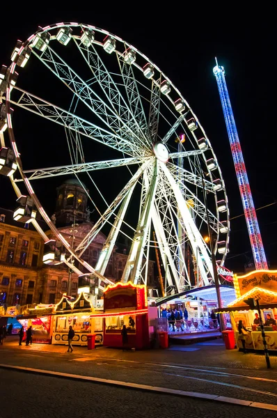 AMSTERDÃO, PAÍSES BAIXOS-ABRIL 27: Roda gigante à noite na Praça Dam durante o Dia do Rei em abril 27.2015 em Amsterdã . — Fotografia de Stock