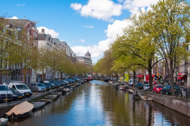 Amsterdam-Nisan 30: Amsterdam cityscape sıra otomobil, Bisiklet ve tekne ile Nisan günü güneşli gün boyunca kanal Park 30,2015, Hollanda.