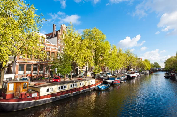 Průplav Amsterdam s lodí podél břehu řeky. — Stock fotografie