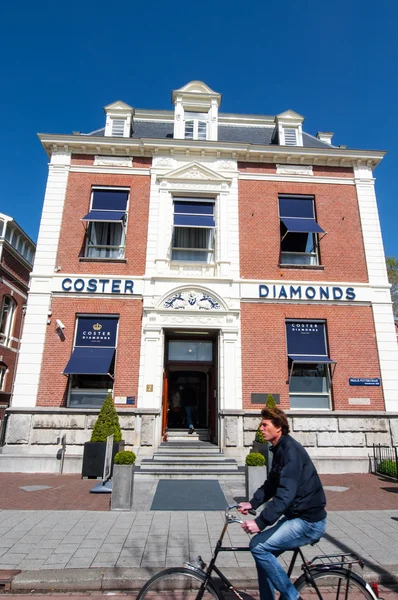 AMSTERDAM-APRIL 30: The Diamond Museum Amsterdam, an inhabitant ride a bicycle on April 30,2015, the Netherlands. — Stock Photo, Image