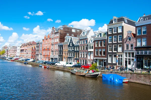 AMSTERDAM-ABRIL 30: Paisaje urbano de Ámsterdam con fila de coches, bicicletas y barcos estacionados a lo largo del canal Singel el 30 de abril de 2015, Holanda . — Foto de Stock