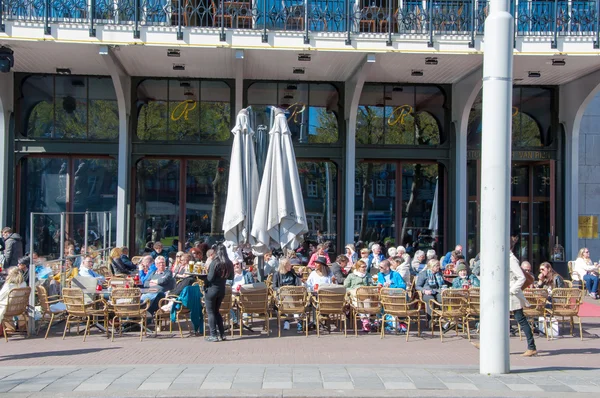 Locals en toeristen hebben dranken in openlucht café op het Rembrandtplein, Nederland. — Stockfoto