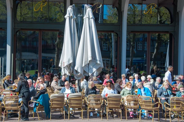Nedefinovaný lidé mají nápoje ve venkovní kavárně s výhledem na náměstí Rembrandtplein, Nizozemsko. — Stock fotografie