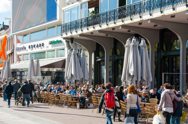 Locals and tourists have drinks in outdoor cafe with Rembrandtplein view, famous Escape club is visible in the background, the Netherlands. — Stok fotoğraf