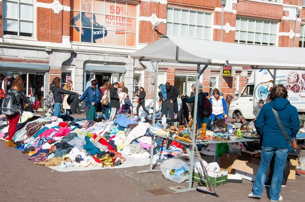 Mensen kopen kleren in een verkoop van dagelijkse vlooienmarkt, Waterlooplein (Waterloo Square), Nederland. — Stockfoto