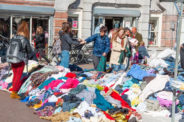 Kleding in een verkoop van dagelijkse vlooienmarkt, Waterlooplein (Waterloo Square), Nederland. — Stockfoto