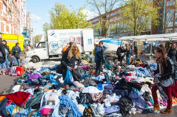 Niet-geïdentificeerde mensen kopen kleren in een verkoop van dagelijkse vlooienmarkt, Waterlooplein (Waterloo Square), Nederland. — Stockfoto