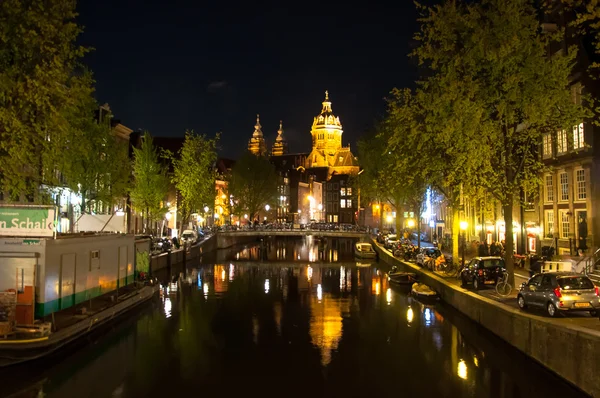 Red light district at night, the Church of St. Nicholas is visible in the distance on April 30,2015, the Netherlands. — Stock Fotó