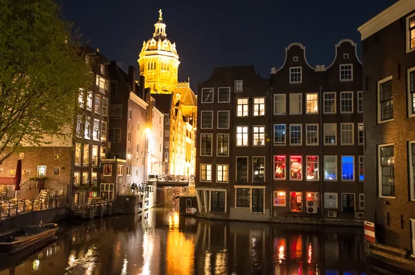 Red light district at night, the Church of St. Nicholas is visible in the distance. — Stockfoto