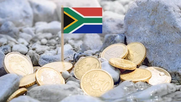 Nehir kıyısında Güney Afrika bayrağı ve avro sikkeleri, dış yatırım, döviz kuru ve Güney Afrika ve Avrupa ekonomisine bağlı uluslararası finansman.