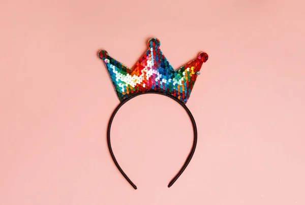 Crown headband lying pink background. Birthday, or coronavirus, covid 19 concept.