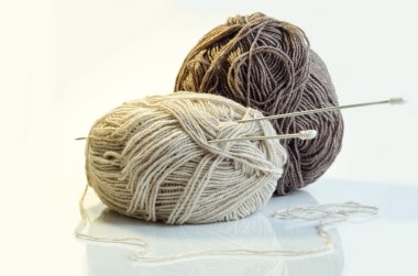 İplik ve örme iğneler beyaz bir arka plan üzerinde iki bobin