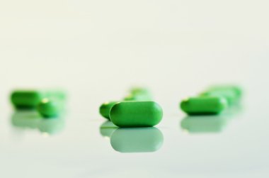 Beyaz arka planda yeşil haplar