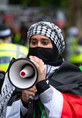 Londra, İngiltere. 22 Mayıs 2021. Londra 'daki Victoria Embankment protestosunda megafonla Filistin yanlısı destekçi, İngiliz hükümetini İsrail' in dokunulmazlıkla hareket etmesine izin vermemek için harekete geçmeye çağırdı..