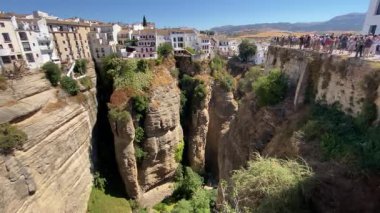 Ronda, İspanya. 31 Ağustos 2025. İspanya 'nın Ronda kentindeki El Tajo geçidine geniş açıdan baktık. Bu açı Puente Nuevo Köprüsü 'nden görülüyor. Uçurumun tepesindeki şehir açık mavi gökyüzüne karşı..