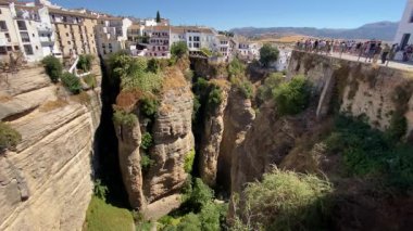 Ronda, İspanya. 31 Ağustos 2025. İspanya 'nın Ronda kentindeki El Tajo geçidine geniş açıdan baktık. Bu açı Puente Nuevo Köprüsü 'nden görülüyor. Uçurumun tepesindeki şehir açık mavi gökyüzüne karşı..