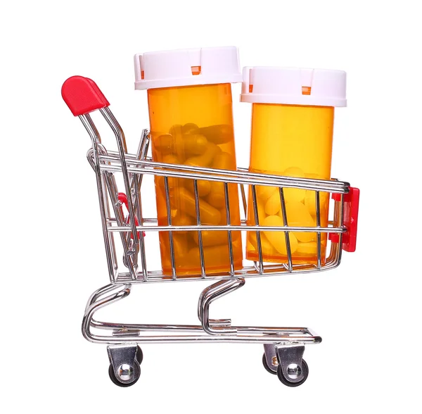 Garrafa de comprimido no carrinho de compras isolado no fundo branco — Fotografia de Stock