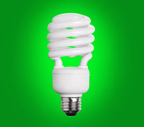 Флуоресцентная лампочка CFL на зеленом фоне — стоковое фото