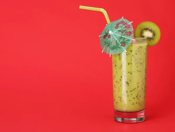 Saludable vaso de licuados sabor kiwi sobre fondo rojo — Foto de Stock