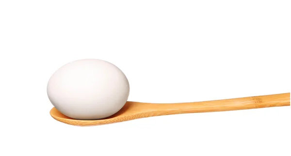 Яйцо на деревянной ложке изолированы на белом фоне — стоковое фото
