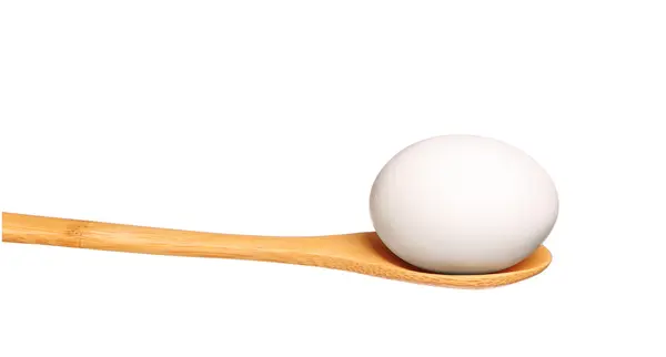 Jajko na drewniane łyżki na białym tle — Zdjęcie stockowe