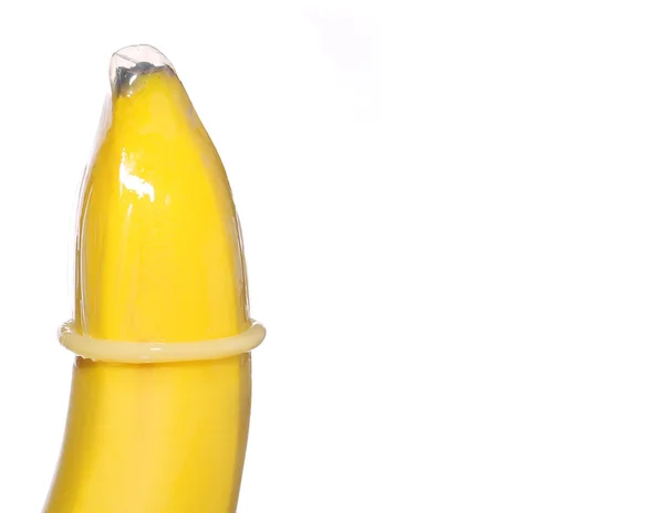 Банан с презервативом на заднем плане. Концепция контрацепции — стоковое фото