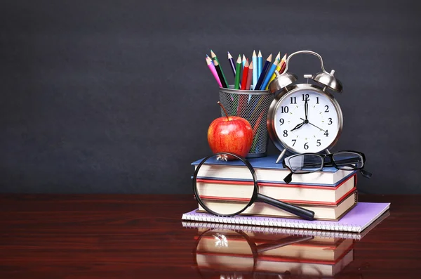 Kitap, apple, çalar saat ve kalem ahşap Resepsiyon Masa ve bla