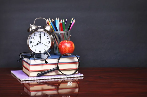 Books, apple, alarm clock and pencils on wood desk table and bla — Stock Photo, Image