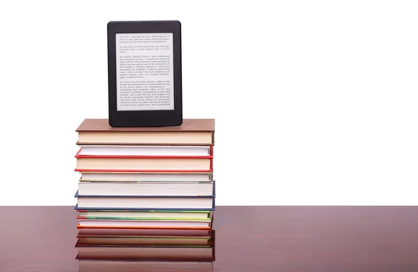 Elektroniczne książki czytelnik i stos starych książek na stole drewniane biurko — Zdjęcie stockowe