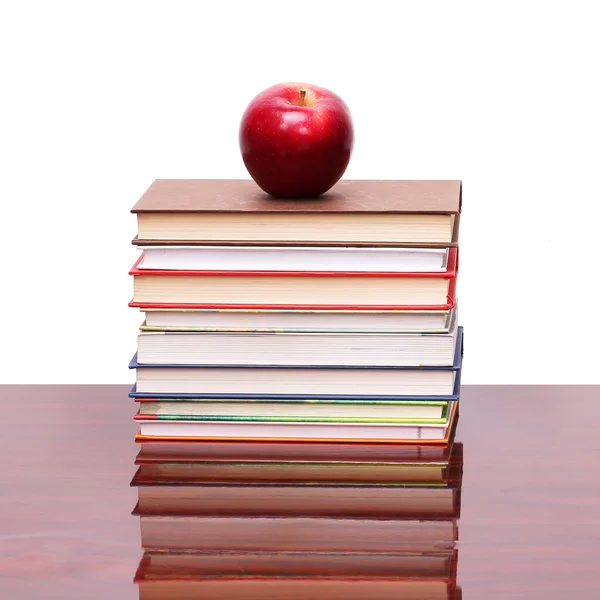 Apfel mit Büchern auf Holztisch — Stockfoto