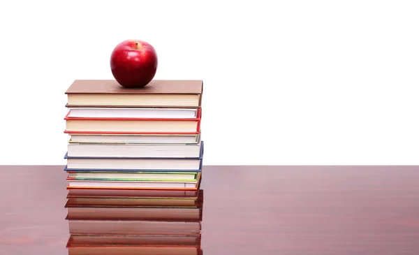 Apfel mit Büchern auf Holztisch — Stockfoto