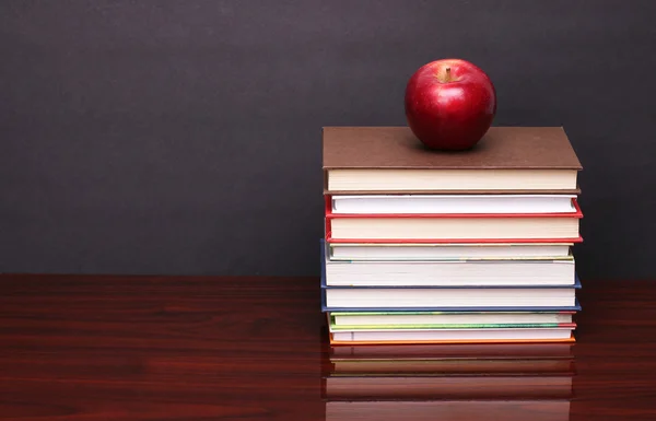 Apfel mit Büchern auf Holztisch — Stockfoto