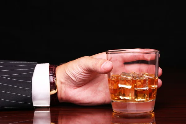 Riche et succès homme d'affaires tenant dans la main verre d'alcool s Images De Stock Libres De Droits