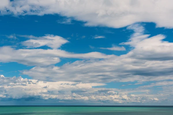 Sakin deniz ve bulutlu gökyüzü mavi. — Stok fotoğraf