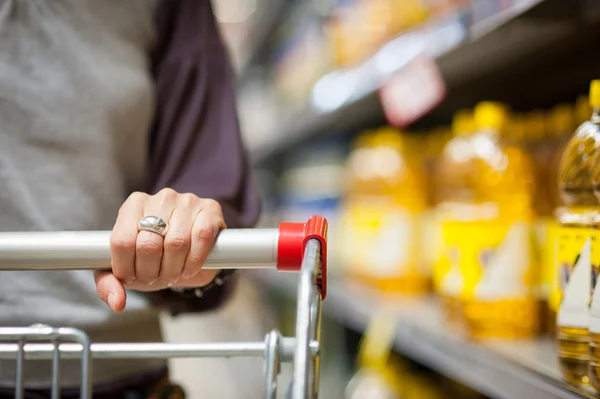 Kvinna hand på nära håll med kundvagn — Stockfoto