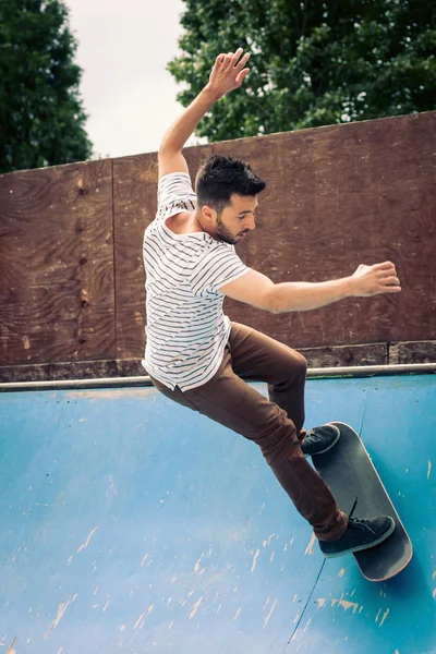 Skateboarder rotolamento giù da halfpipe a skatepark . — Foto Stock