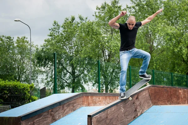 Skater robi trick deskorolka w skateparku. — Zdjęcie stockowe