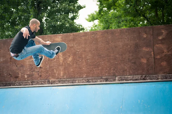 Скейтбордист стрибає в напівтрубку на скейтпарку . — стокове фото