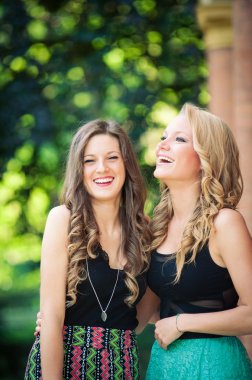 İki güzel kız açık havada birlikte gülüyor