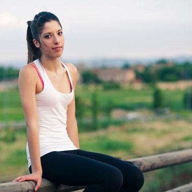 Genç kadın bir çit otur rahatlatıcı