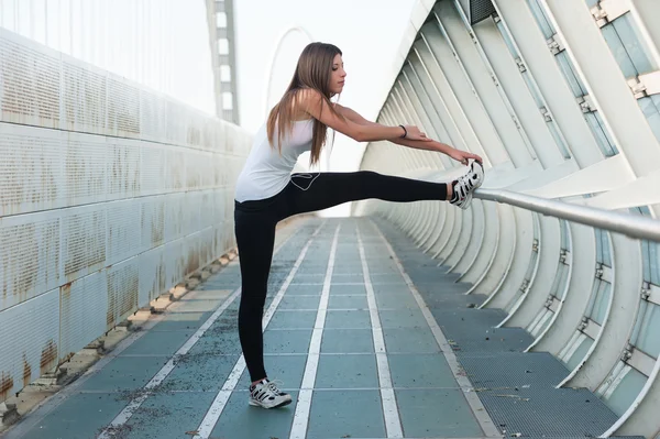 Genç kadın bacaklarını açık havada germe — Stok fotoğraf